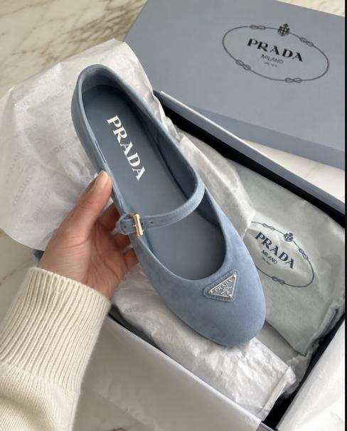 Powder-blue Prada suede Mary Jane flat with triangle logo buckle, shown inside its signature box with dust bag